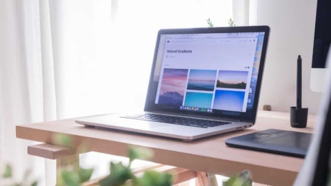 Laptop mit aufgeklapptem Bildschirm steht auf dem Schreibtisch