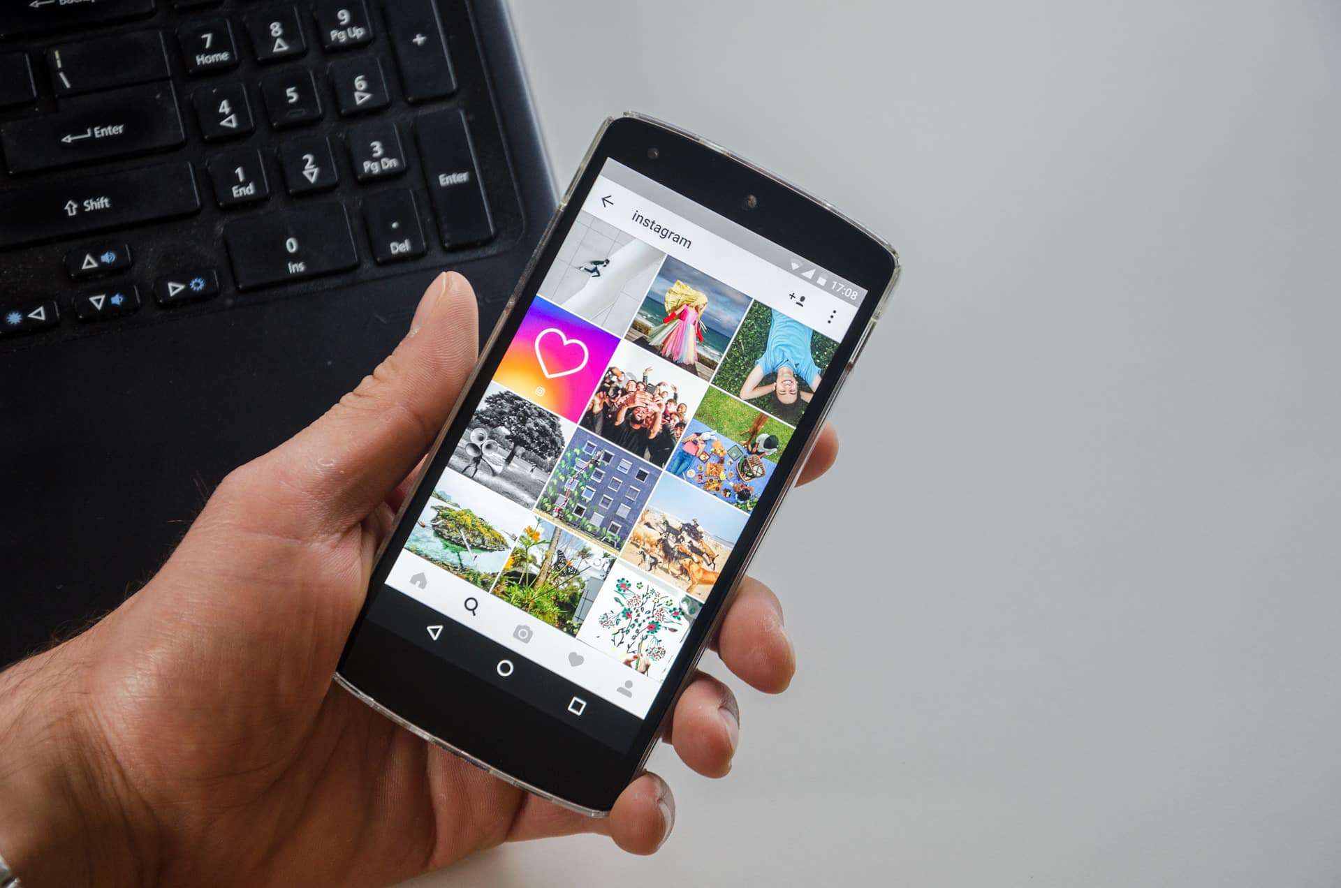 View of a smartphone in the hand - it shows an Instagram feed. Embed Instagram on the homepage - the topic of the blog post is symbolised here.