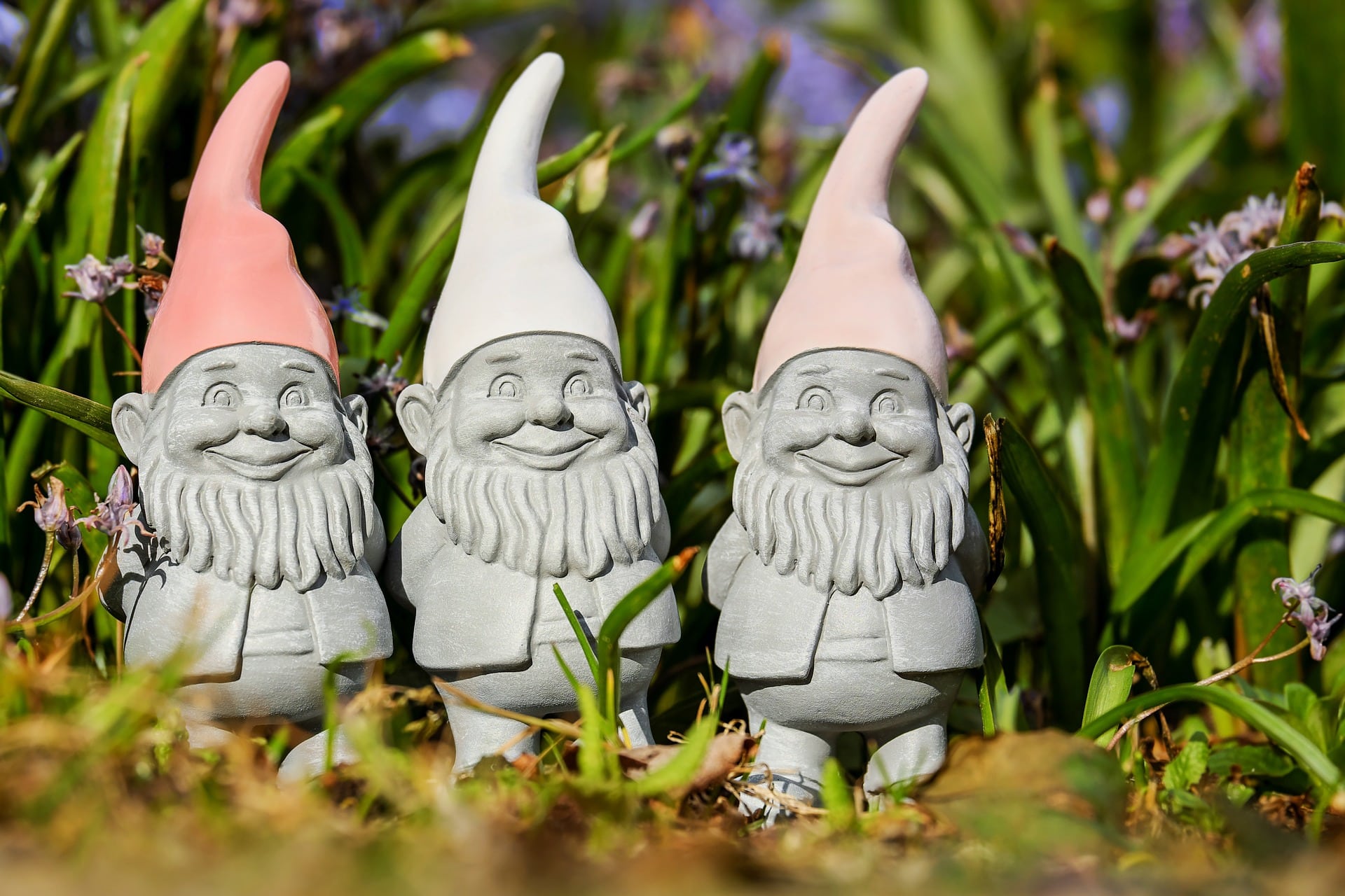 Three smiling garden gnomes stand for good neighbourliness